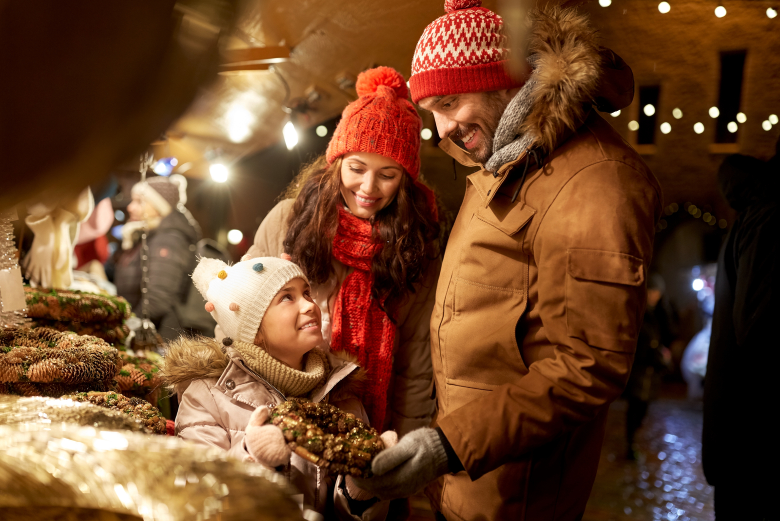 gezin op kerstmarkt aan kraampje